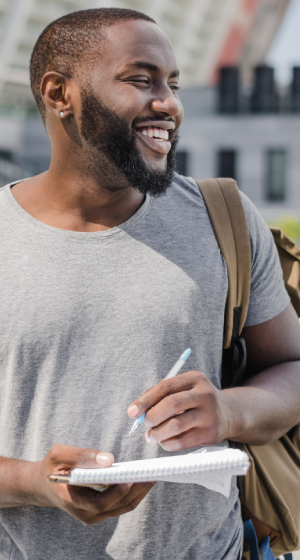 Man smiling while taking notes